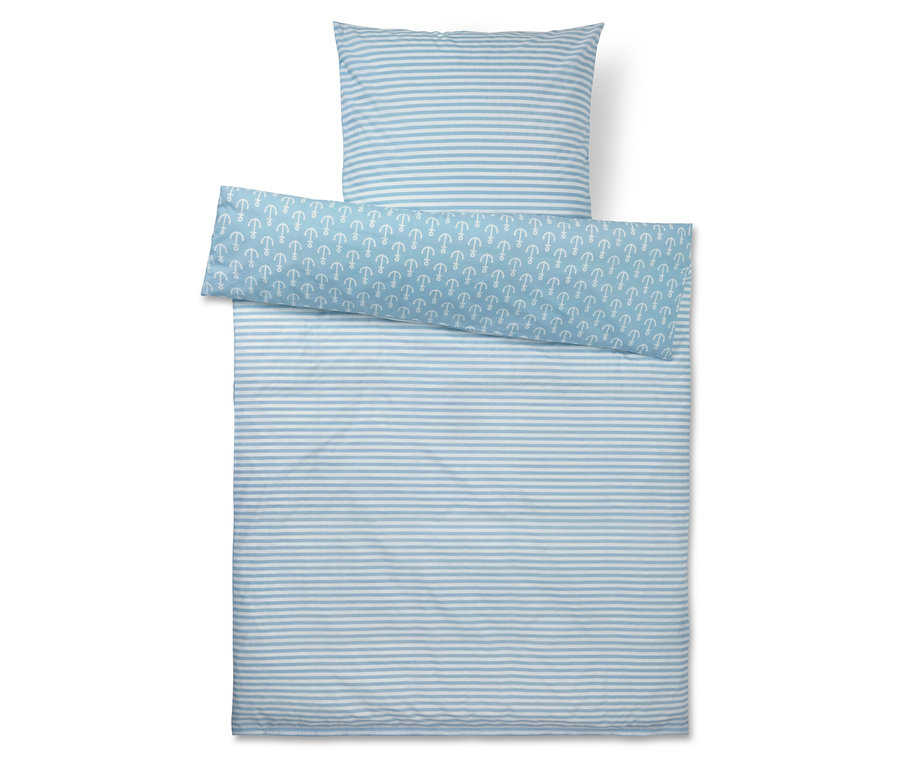 Draufsicht auf ein blau-weiß gestreiftes Bettzeug-Set mit einem Kissen, einer Decke und einem Bezug mit Anker-Muster.