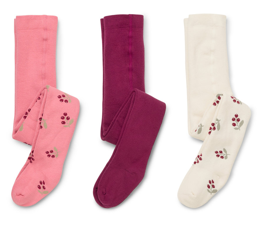 Drei Paar Strumpfhosen liegen auf weißem Grund, einmal rosa mit Beerenmuster, einmal weinrot und einmal creme mit Beerenmuster.