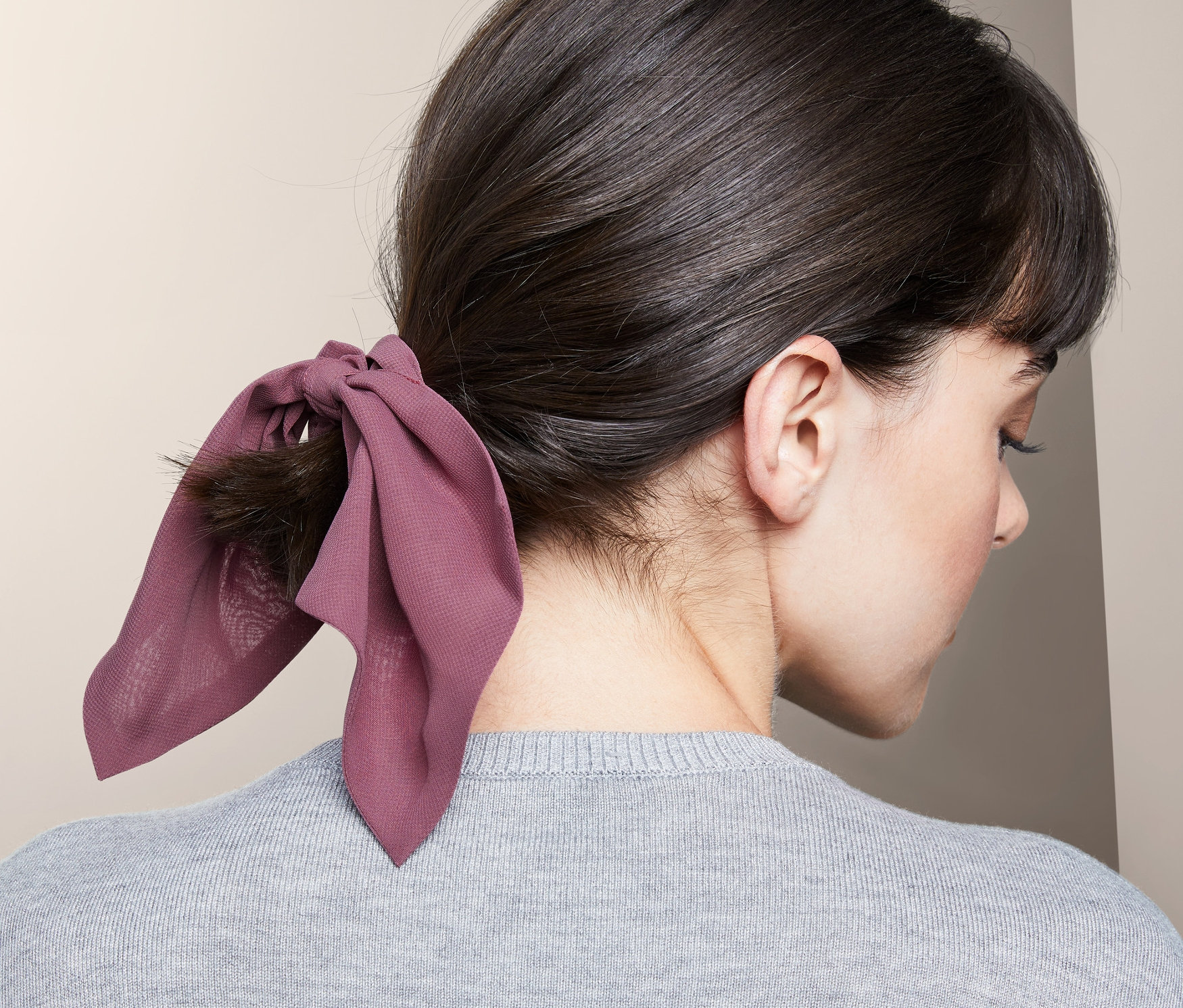 Frau trägt 2 Haargummis »Scrunchies« mit Schleife im Haar.