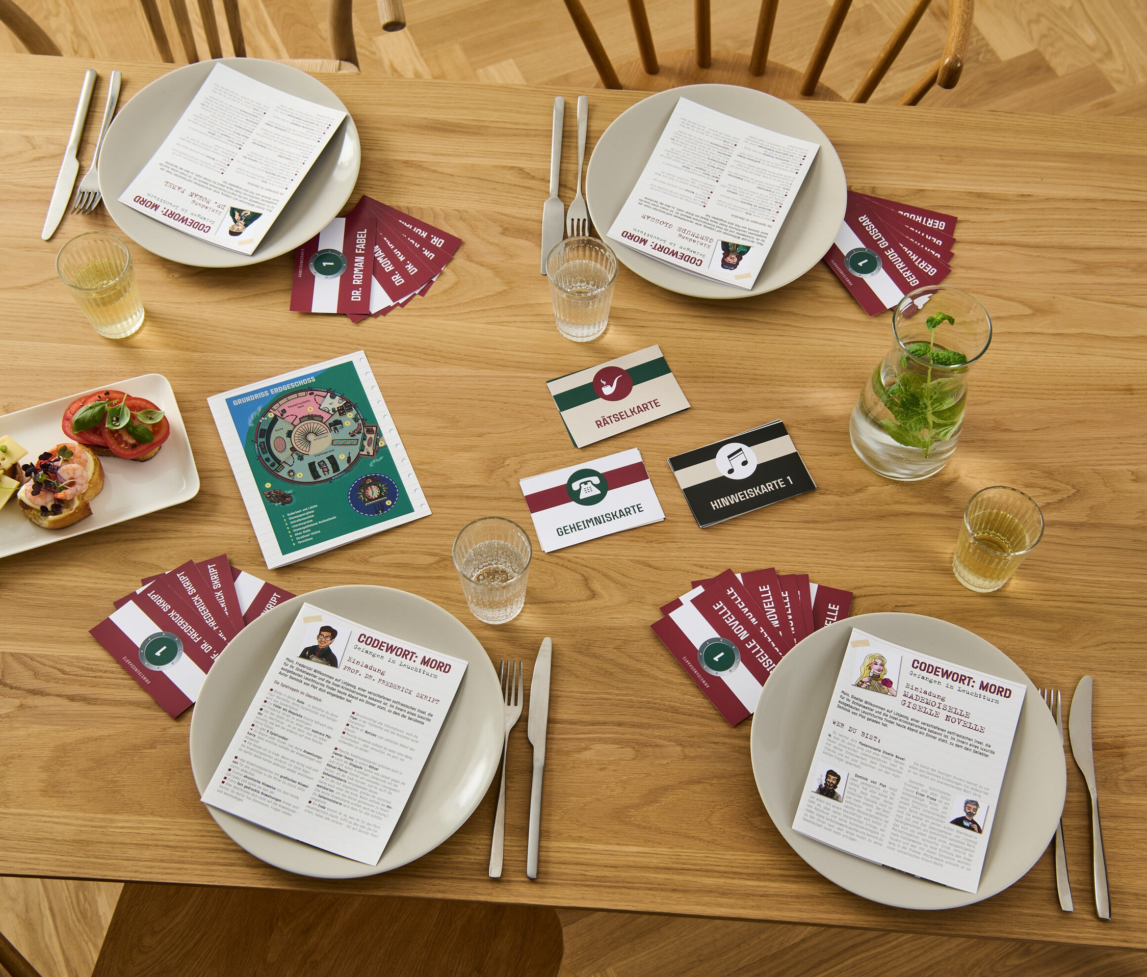 Auf einem Holztisch liegen Teller mit Karten und Getränken für das Krimispiel "Codewort: Mord – gefangen im Leuchtturm".