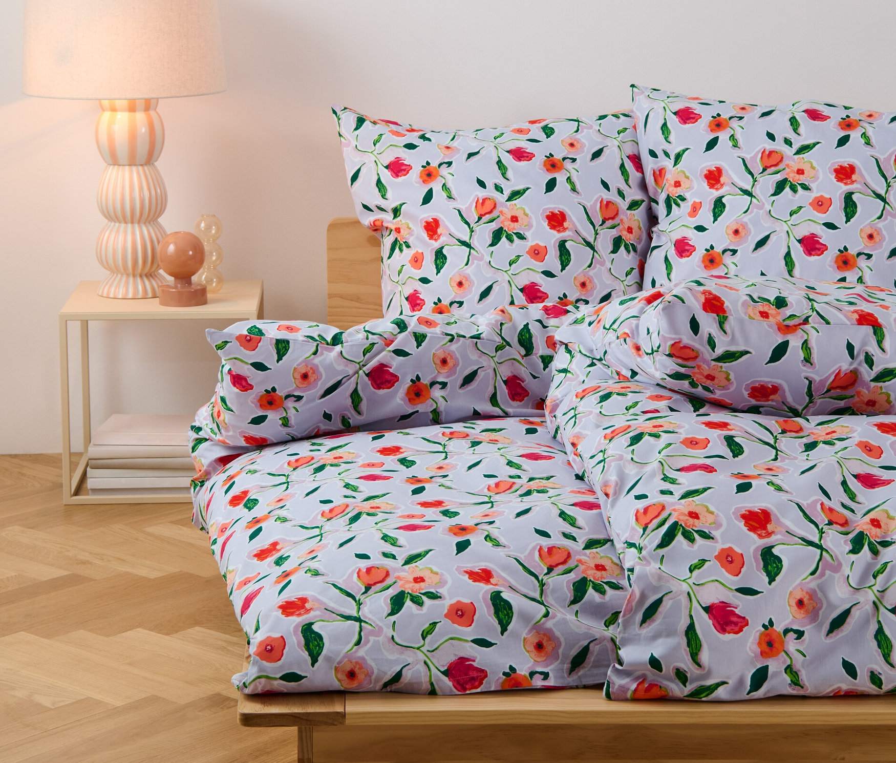 Blumige Renforcé-Bettwäsche in Normalgröße auf einem Bett.