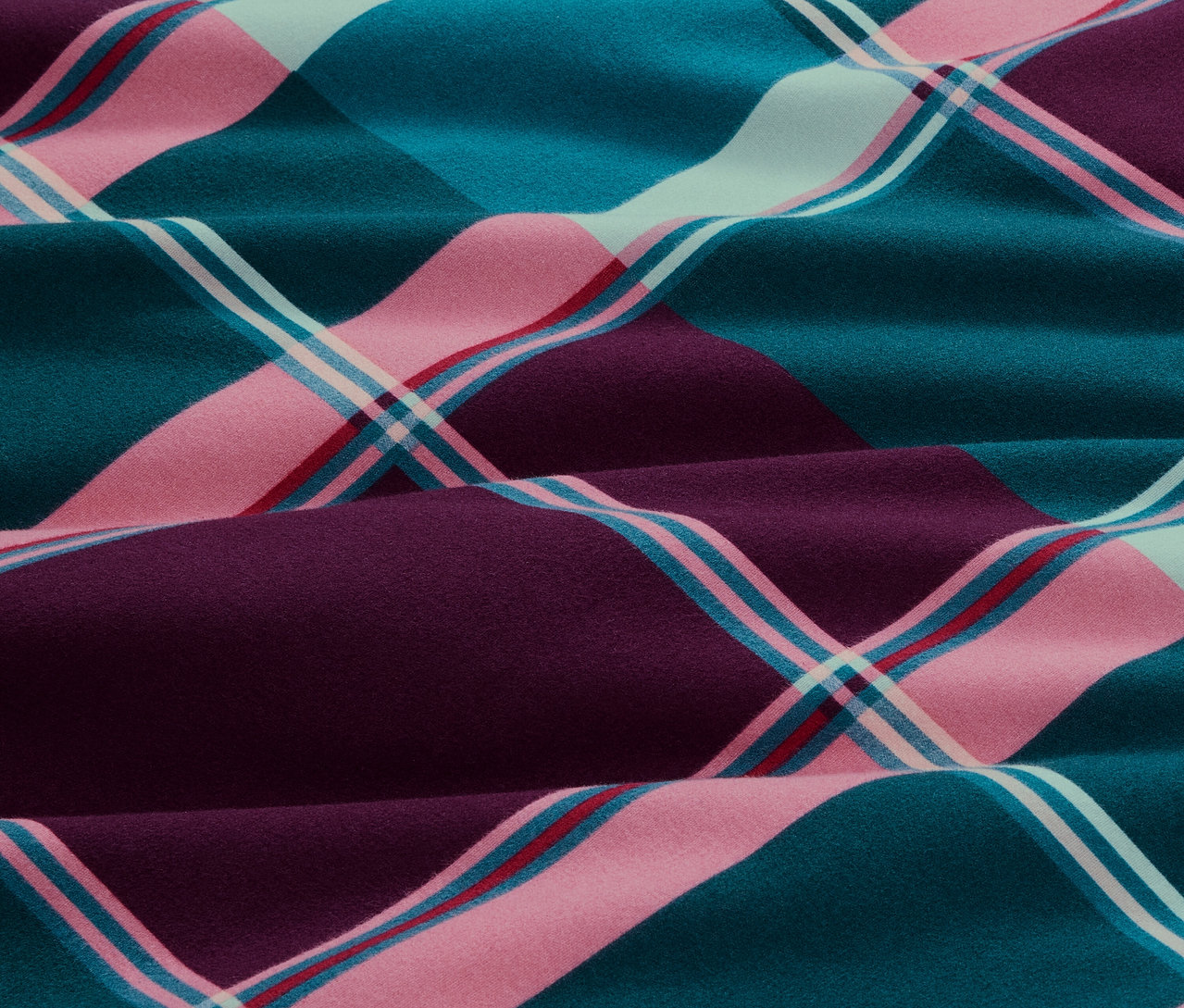 Nahaufnahme von Biber-Bettwäsche, Normalgröße, in einem Karomuster aus Blau-, Rosa- und Lilatönen.