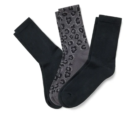 Drei Paar Socken, schwarz und grau, liegen auf einem weißen Hintergrund.