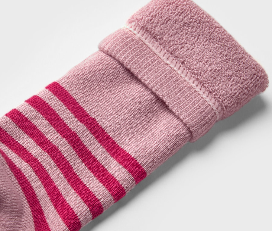 Detailaufnahme einer Kinder-Gummistiefel-Socke (2 Paar, geblümt). Die Socke ist rosa mit roten Streifen und hat einen umgeschlagenen Rand.
