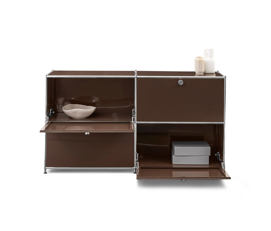 Braunes modulares Sideboard mit Metallrahmen. Links oben eine helle Schale, unten eine offene Klappe. Rechts oben eine geschlossene Tür mit Schloss, darauf zwei Vasen. Unten eine offene Klappe mit zwei grauen Boxen.