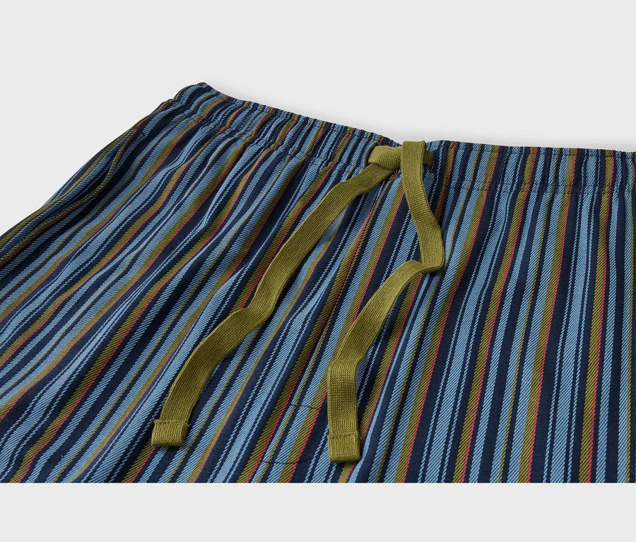 Nahaufnahme einer gestreiften Hose mit elastischem Bund und olivgrünem Kordelzug. Die Hose hat vertikale Streifen in Blau-, Olivgrün- und einem Hauch Rotorange-Tönen.