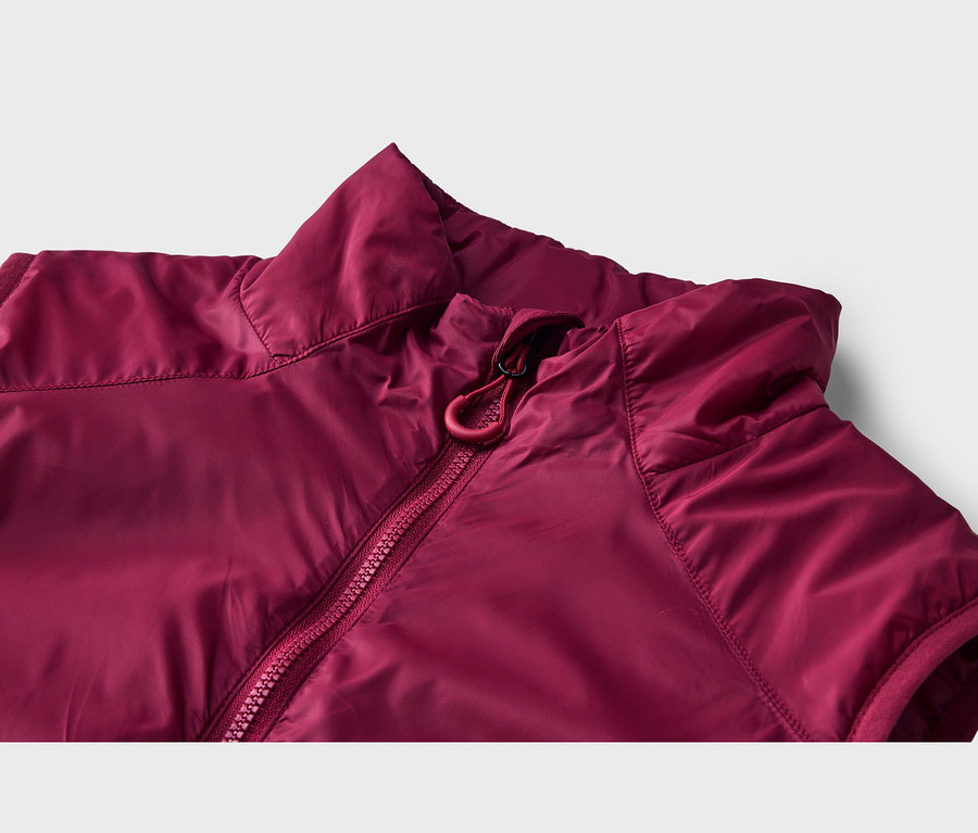 Nahaufnahme einer bordeauxroten ärmellosen Jacke mit Stehkragen und rotem Reißverschluss mit Kordelzug.