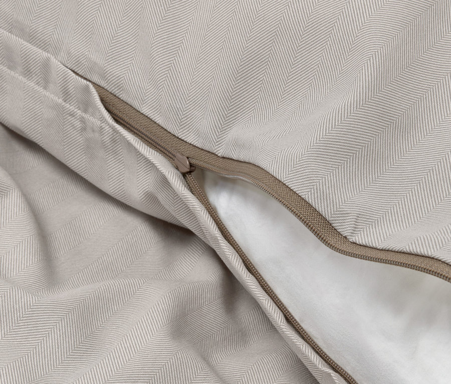 Nahaufnahme von Edelflanell-Bettwäsche mit Fischgrätenmuster und Reißverschluss.