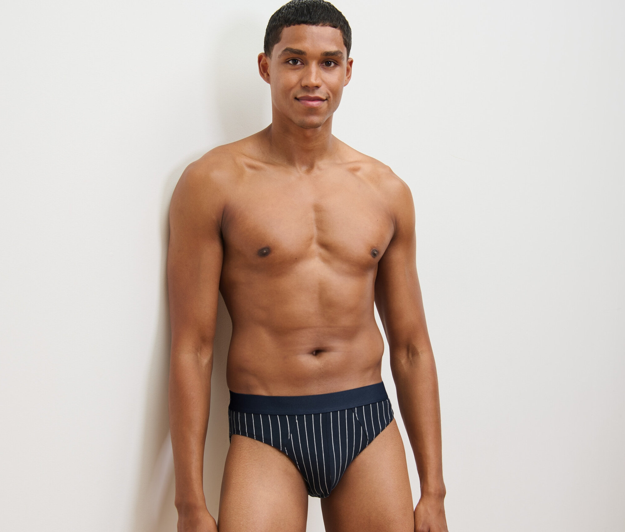 Mann posiert in gestreiften 4 Slips.