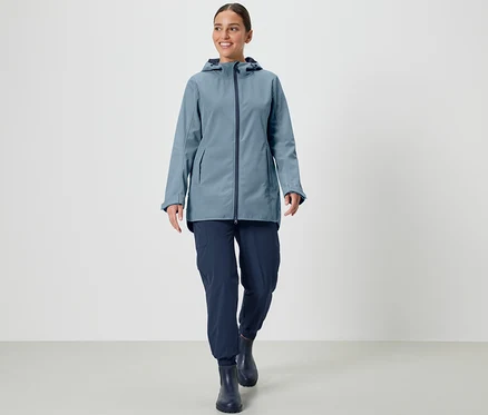 Frau trägt eine Softshelljacke und geht.