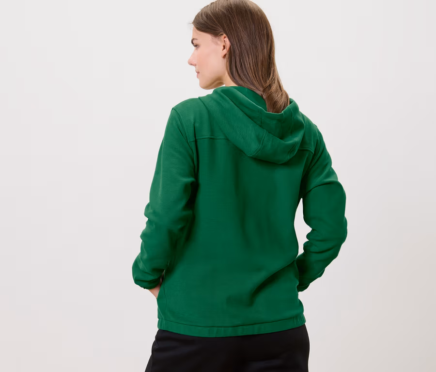 Frau von hinten trägt eine grüne Sweatjacke.