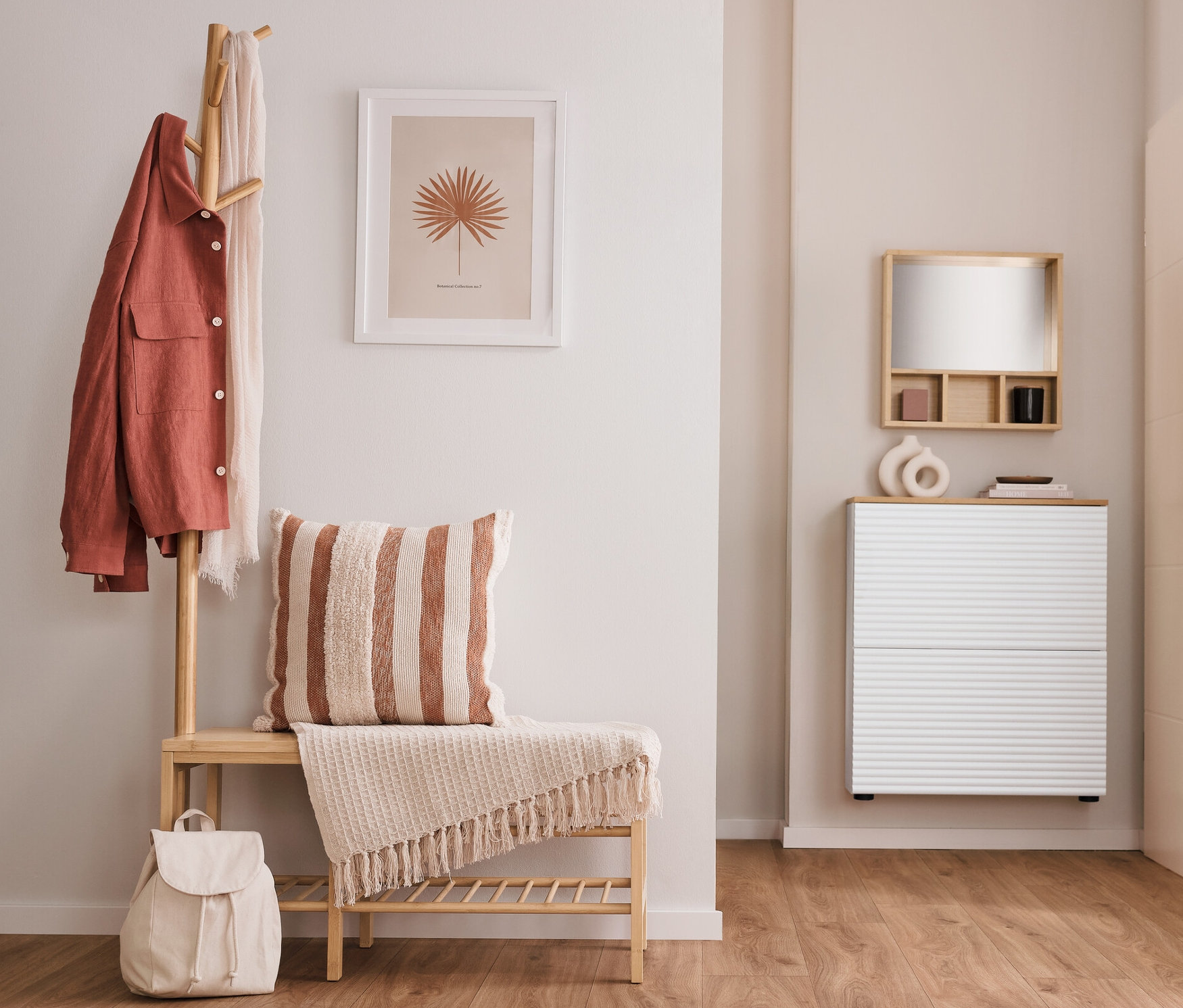 Im Flur stehen eine Sitzbank mit Garderobenständer, ein Schuhkipper mit 2 Fächern und ein Spiegel mit Ablageflächen.