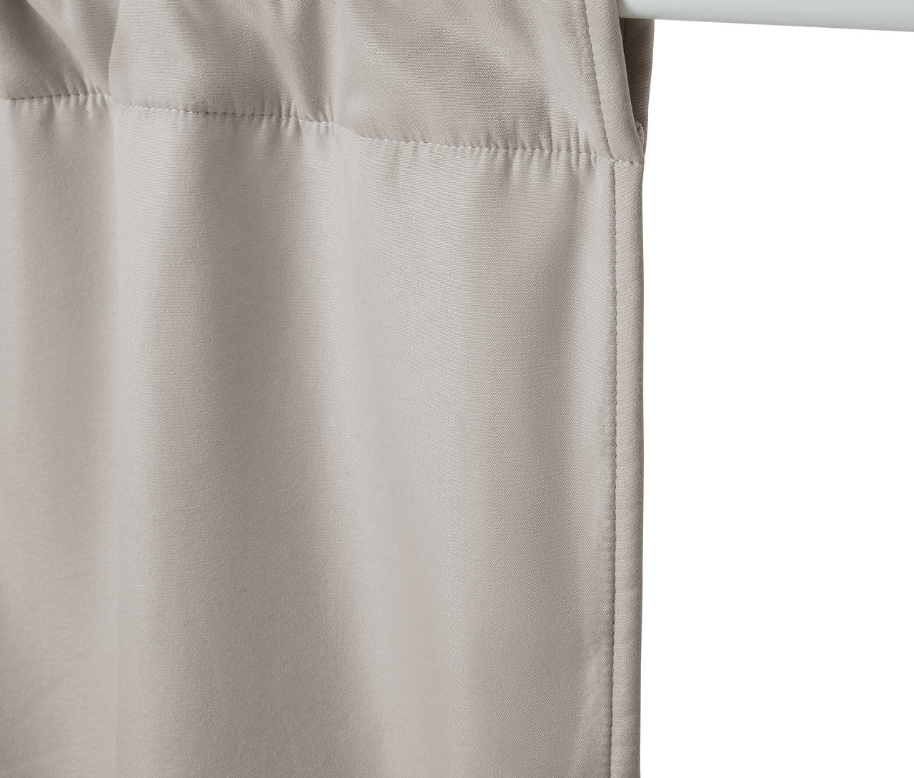 Beige Vorhänge hängen an einer weißen Stange.