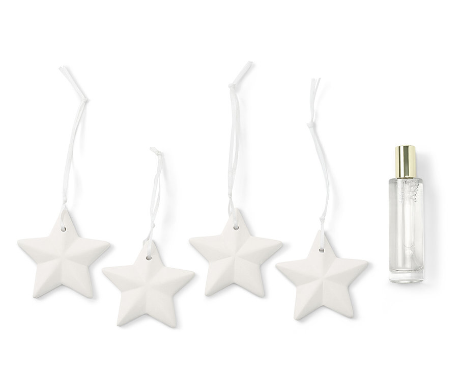 Vier weiße Sterne an einer Schnur neben einer durchsichtigen Sprühflasche.