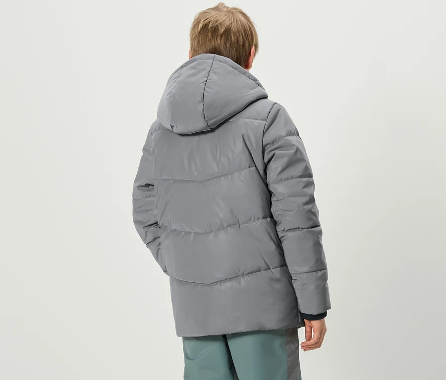 Ein Junge mit dem Rücken zur Kamera trägt eine graue Reflektierende Kinder-Steppjacke und eine Hose.
