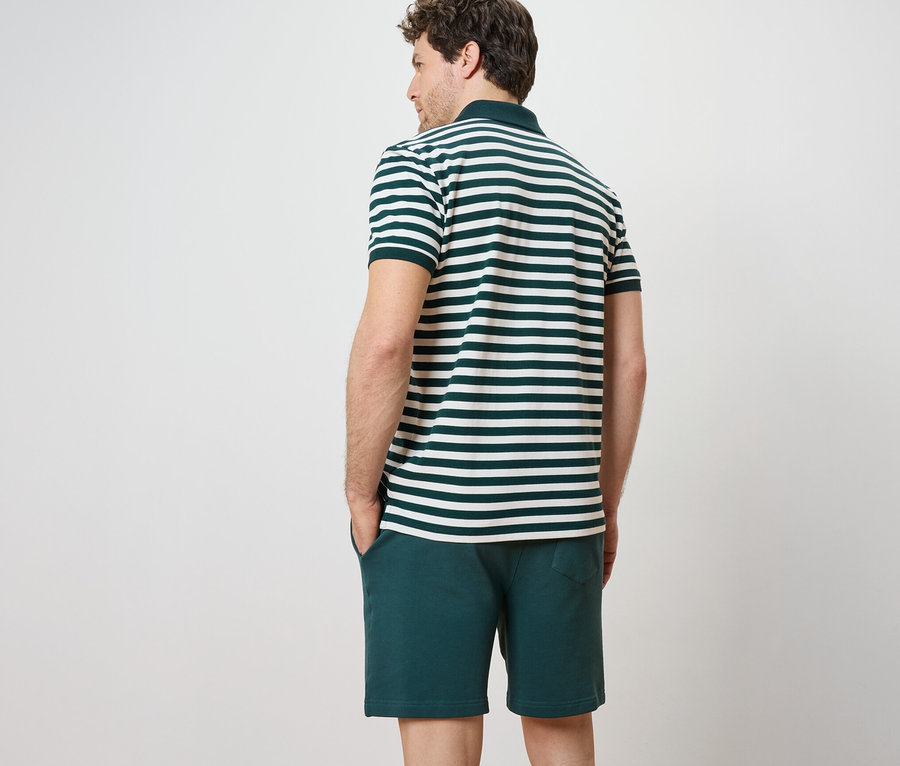 Mann von hinten trägt ein gestreiftes Piqué-Poloshirt mit kurzen Ärmeln und Shorts.
