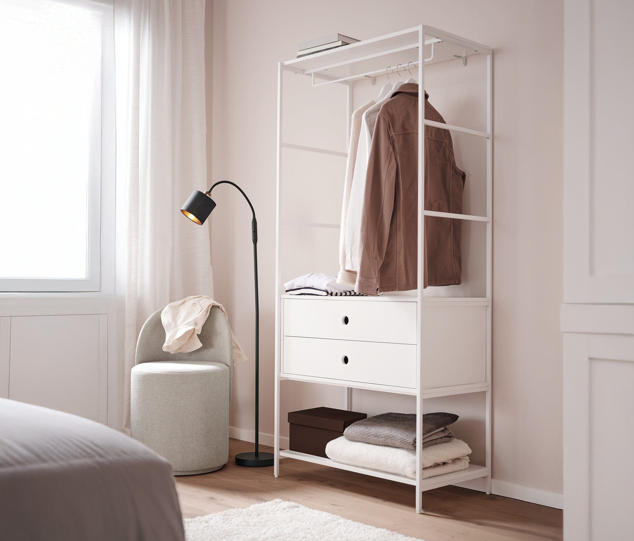 Ein Drehhocker mit Rückenlehne steht neben einer weißen Garderobe »KLAAR« mit 2 Schubladen in einem Schlafzimmer.