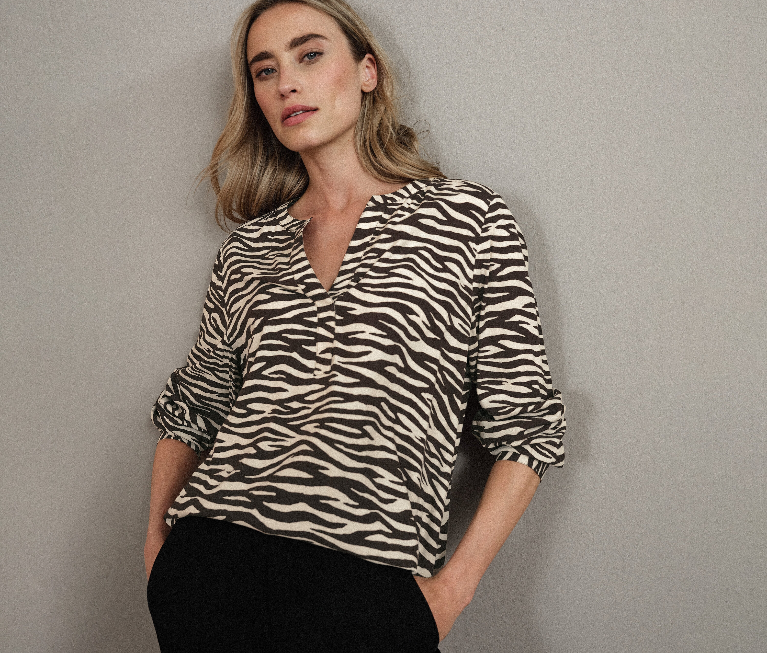 Blonde Frau trägt eine Street One Bluse mit Zebra-Muster.