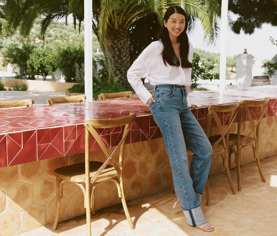 Frau posiert an einer Bar im Freien und trägt hellblaue Angels Jeans »Lara« Straight Fit Turn Up.