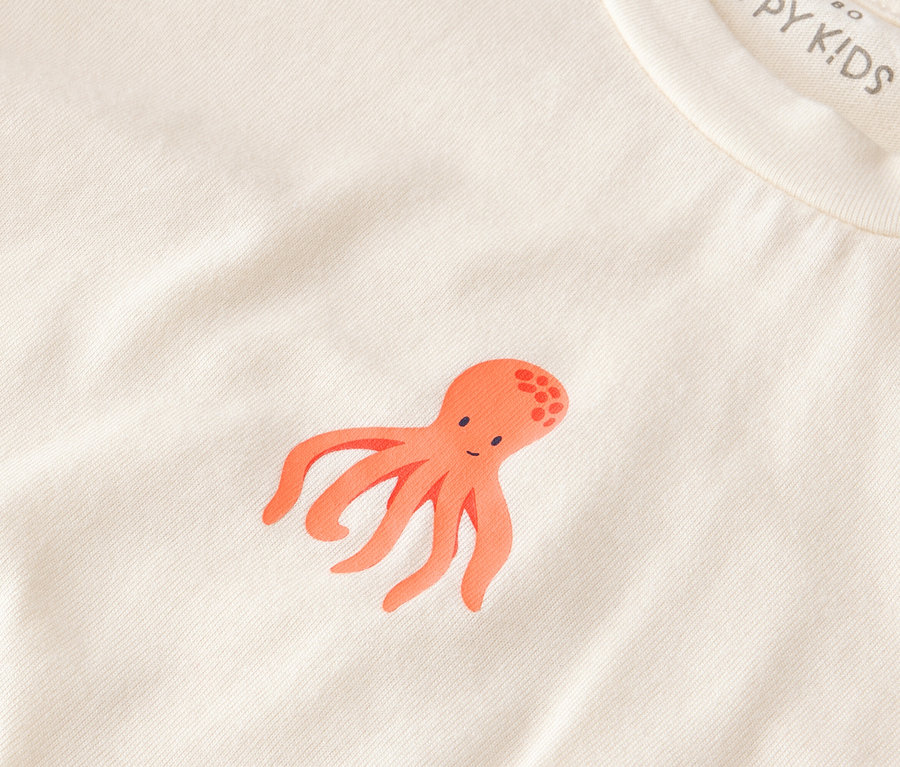 Nahaufnahme eines 2 Kinder-Shorty-Pyjamas, Hai mit einem orangefarbenen Tintenfisch darauf.