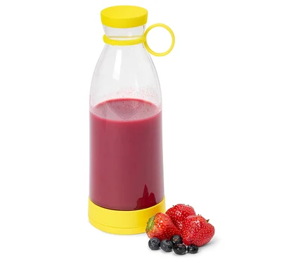 Eine klare Flasche mit gelbem Deckel gefüllt mit rotem Smoothie, daneben Erdbeeren und Blaubeeren.