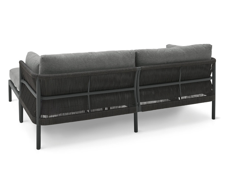 Rückansicht eines grauen Sofas mit dunklem Rattangeflecht und Metallrahmen.