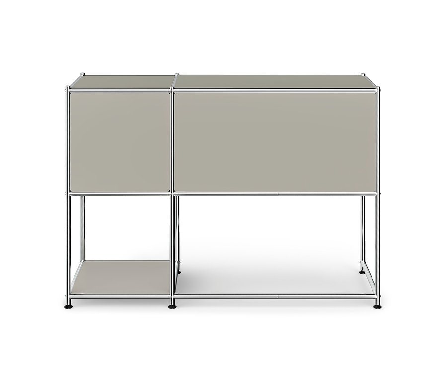 Modulares Möbelstück mit Chromrahmen und hellgrauen Paneelen, bestehend aus zwei geschlossenen oberen Fächern, einem offenen Regal unten links und einem offenen Bereich unten rechts.