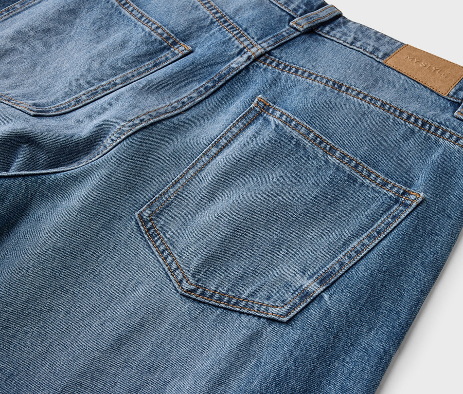 Rückansicht einer hellblauen Jeans mit zwei sichtbaren Gesäßtaschen, kontrastierenden braunen Nähten und einem braunen "MY STYLE"-Markenetikett am Bund.