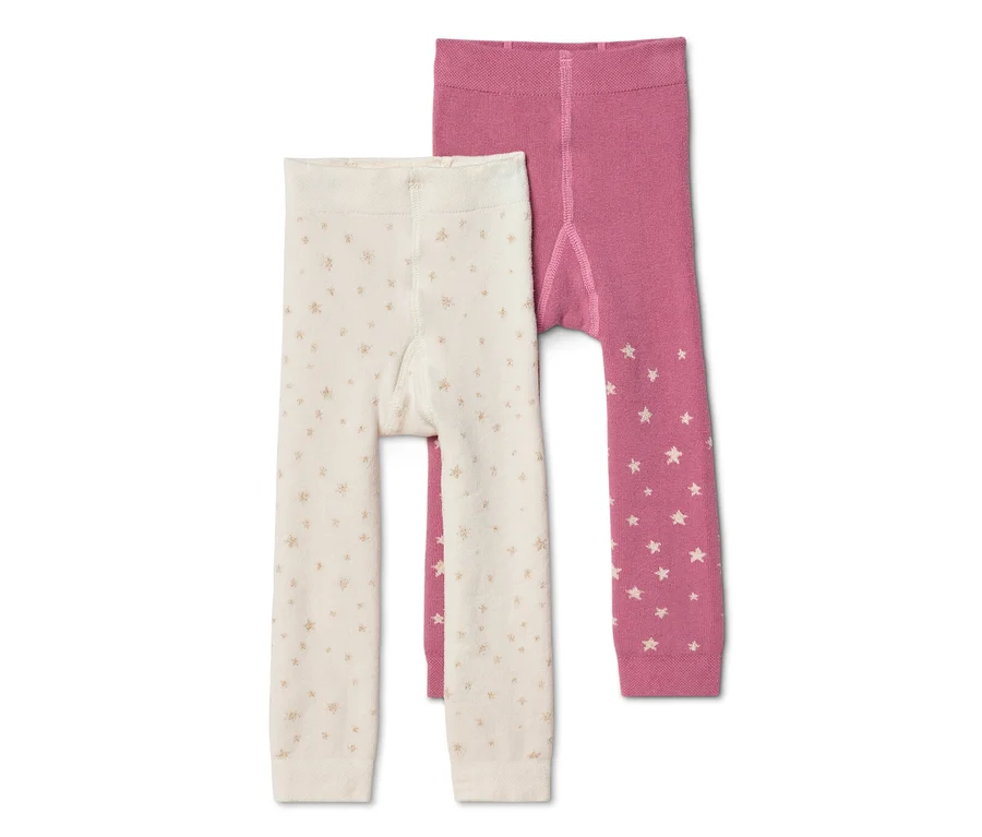 Zwei Baby-Strumpfhosen. Eine cremefarbene mit kleinen goldenen Sternen, die andere rosa mit weißen Sternen an den Unterschenkeln.