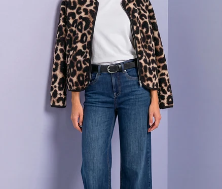 Frau in Street One Jacke mit Leopardenmuster, weißem T-Shirt, blauen Jeans und schwarzem Gürtel.