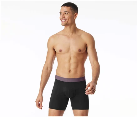 Mann trägt schwarze, lange SCHIESSER Slipboxer mit lila Bund und lächelt.