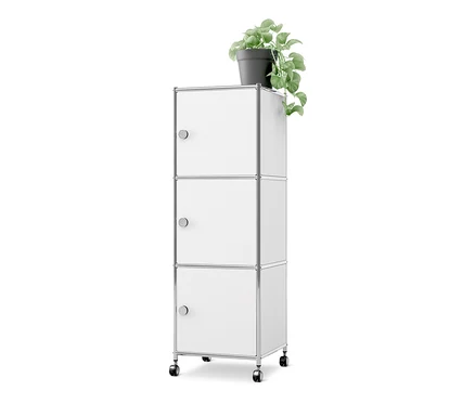 Weißer Metall-Rollcontainer «CN3» mit 3 Türen und Rollen, darauf eine grüne Pflanze in einem Topf.