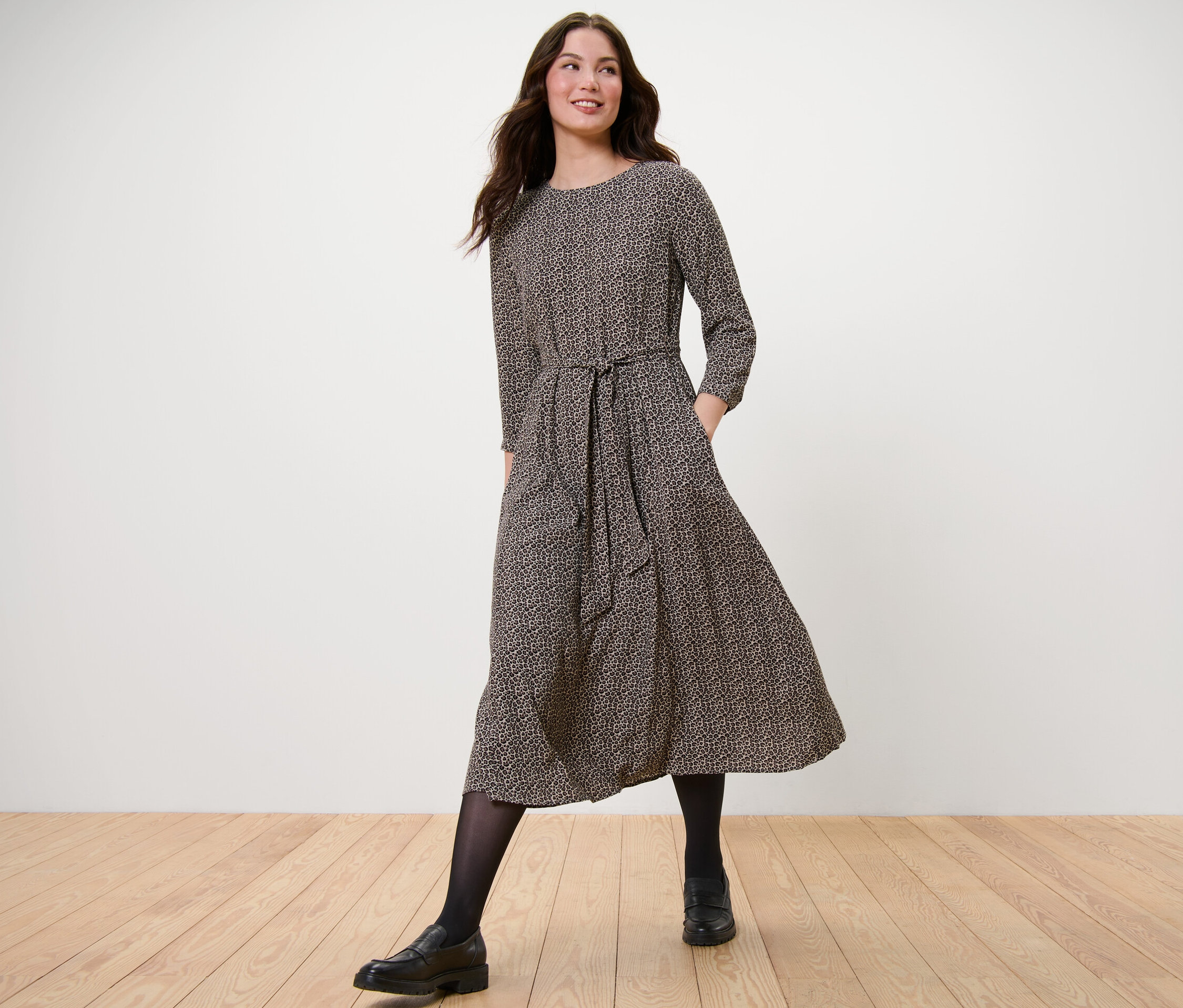 Frau geht und trägt ein bedrucktes Webkleid.