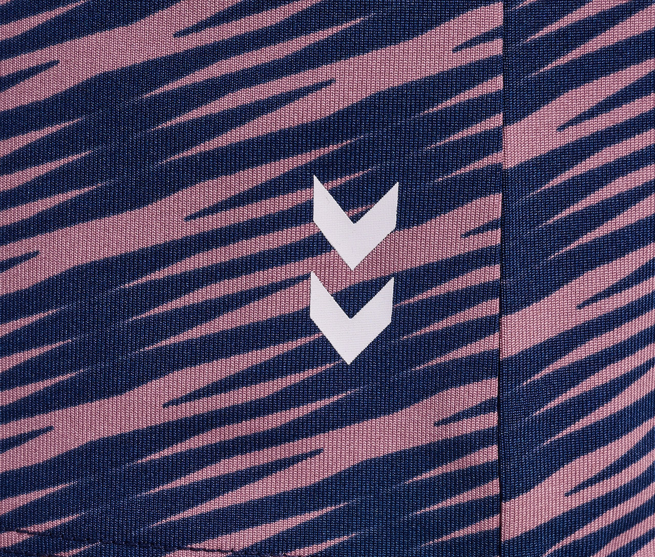Detailansicht des Musters auf einem HUMMEL HMLJR Mix S/S T-Shirt, mit dunkelblauen und pinken Streifen und Logo.