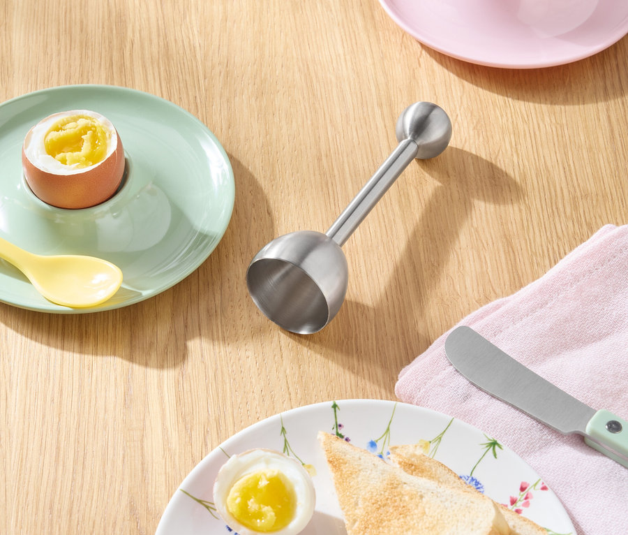 Toast, Eier und Messer auf einem Holztisch.