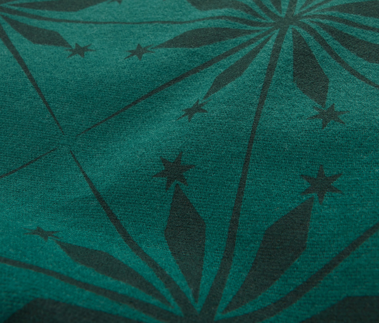Nahaufnahme eines dunkelgrünen Stoffes mit schwarzem Sternmuster.