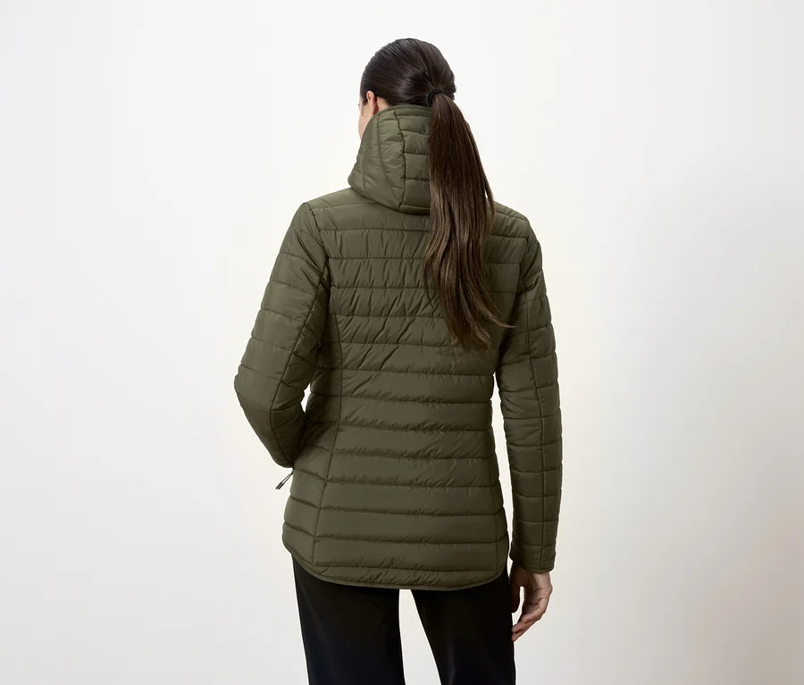 Rückansicht einer Frau in olivgrüner Steppjacke und schwarzer Hose.