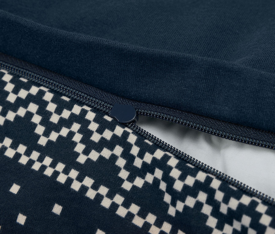Nahaufnahme eines teilweise geöffneten marineblauen Bettbezugs mit Reißverschluss und Schachbrettmuster.
