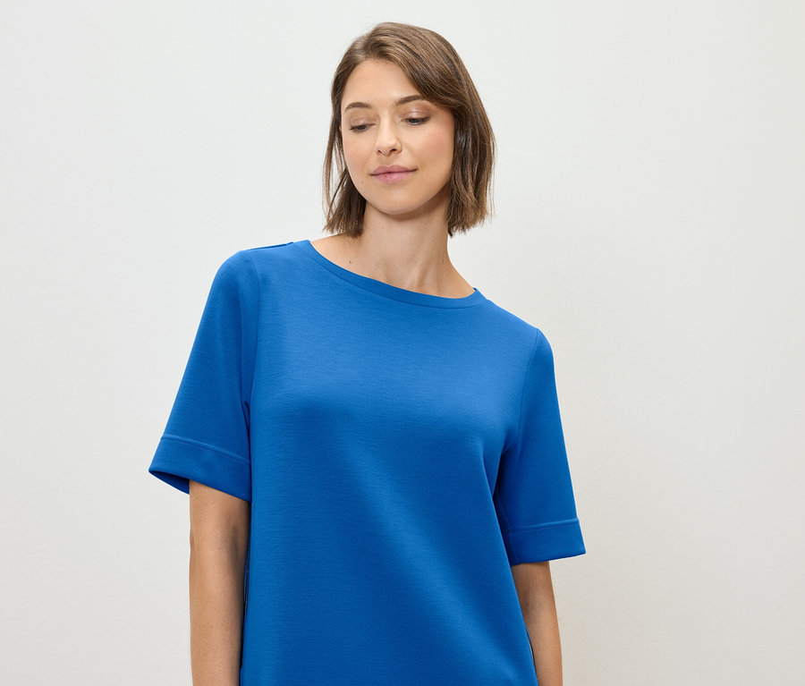Frau trägt ein blaues T-Shirt.