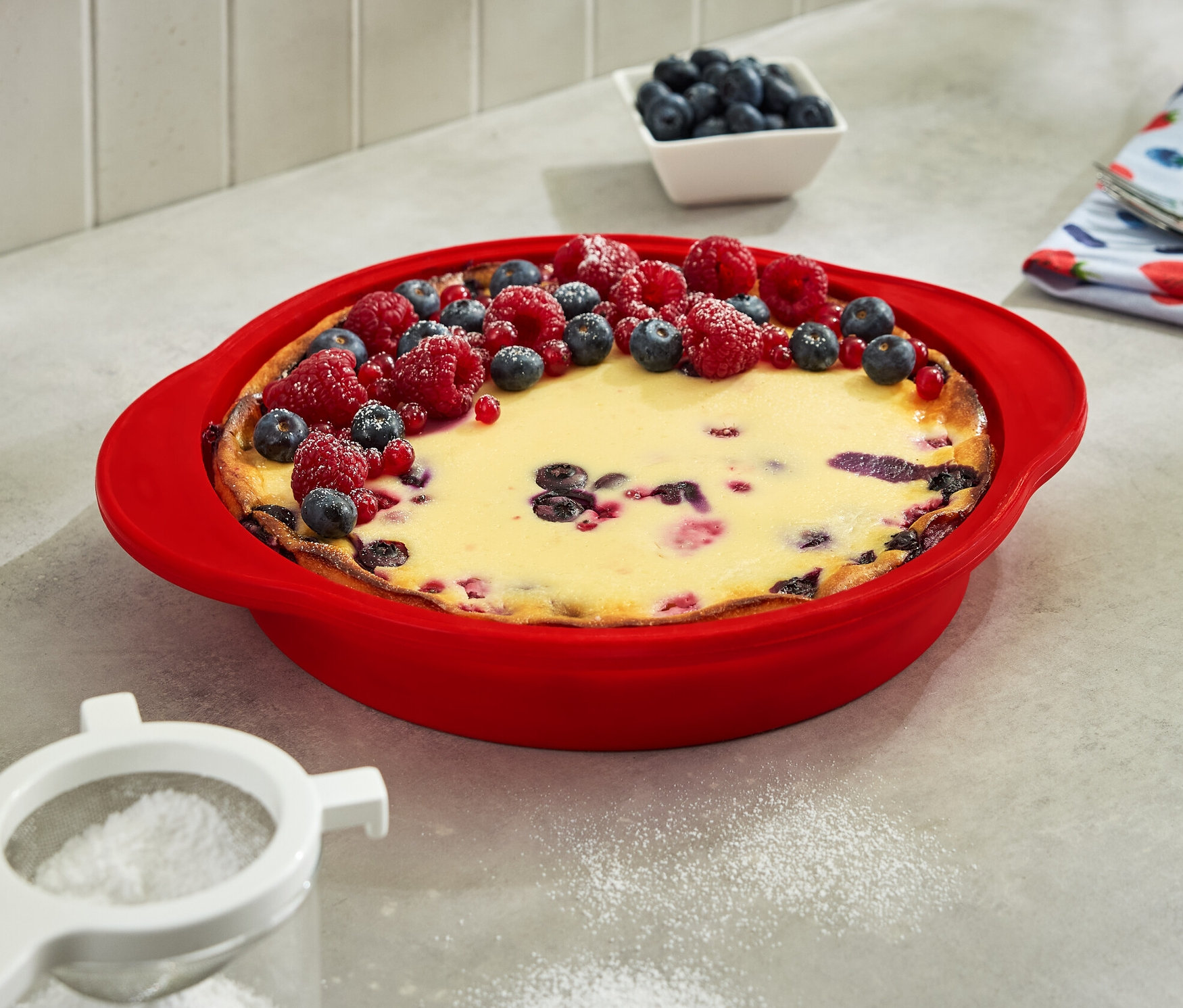 Kuchen in faltbarer Kuchenform, garniert mit Blaubeeren und Himbeeren.