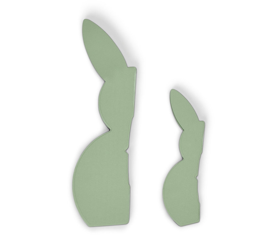 Zwei hellgrüne Hasen-Dekorationen liegen auf einem weißen Untergrund.
