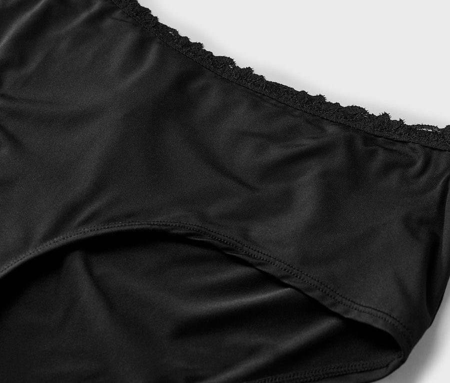 Nahaufnahme eines schwarzen Damenslips mit Spitzendetails am Bund.