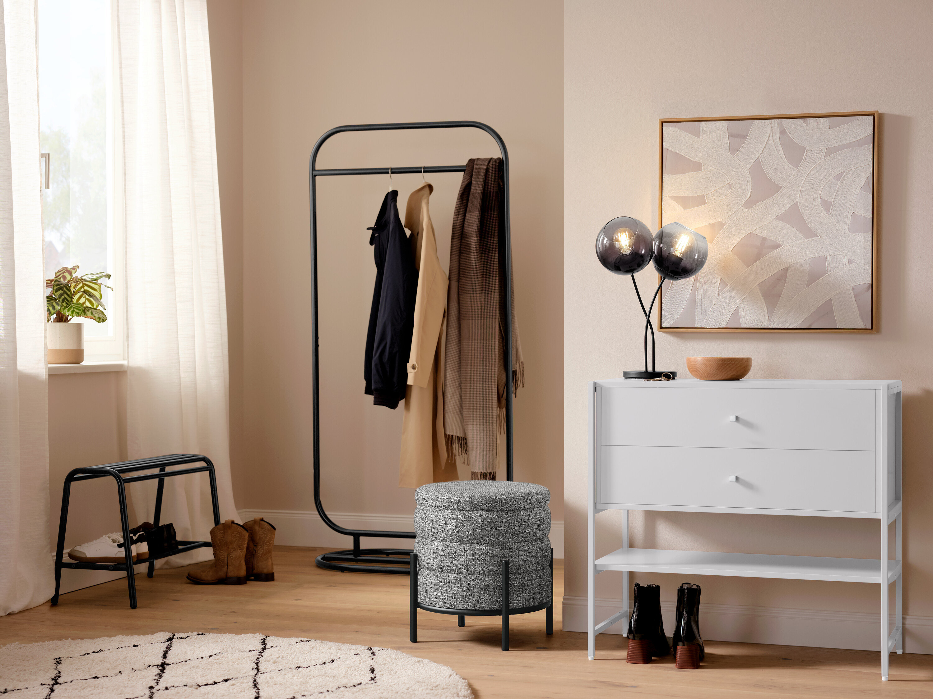 Flur mit einer Tischleuchte mit Schirmen aus Rauchglas, einem Indoorteppich »NOMAD Rhombus Line« und einer Garderobe.