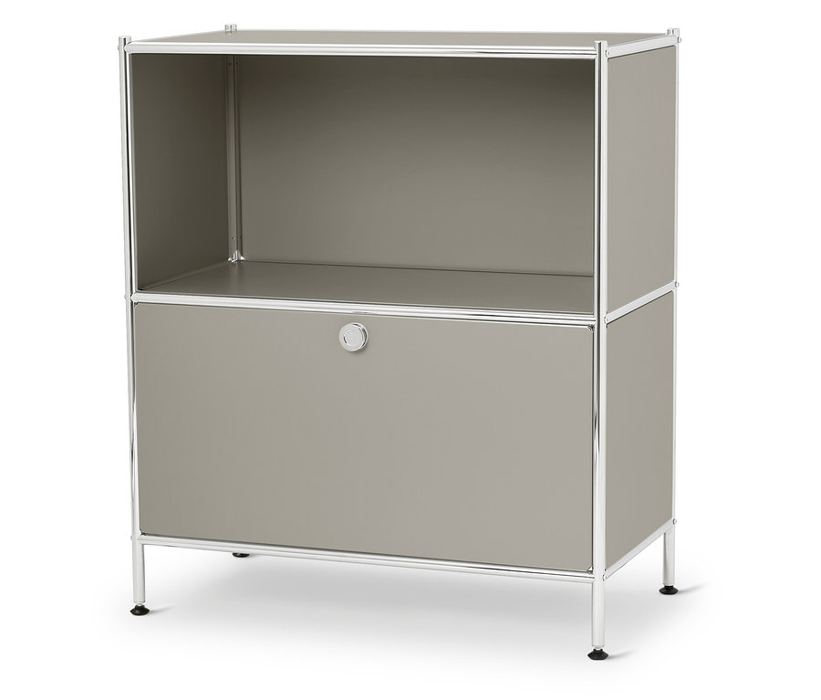 Ein graues Regal mit einem offenen Fach oben und einer geschlossenen Tür unten steht auf einem weißen Untergrund.