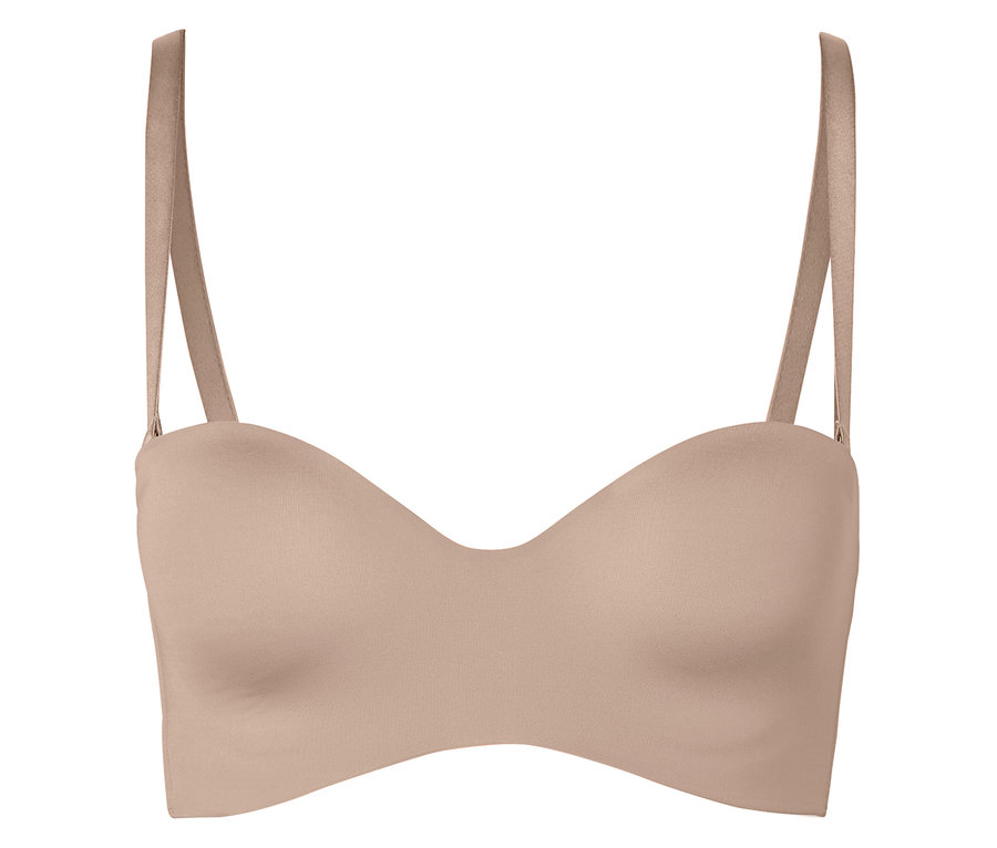 Ein hautfarbener trägerloser BH mit Trägern liegt vor einem weißen Hintergrund.