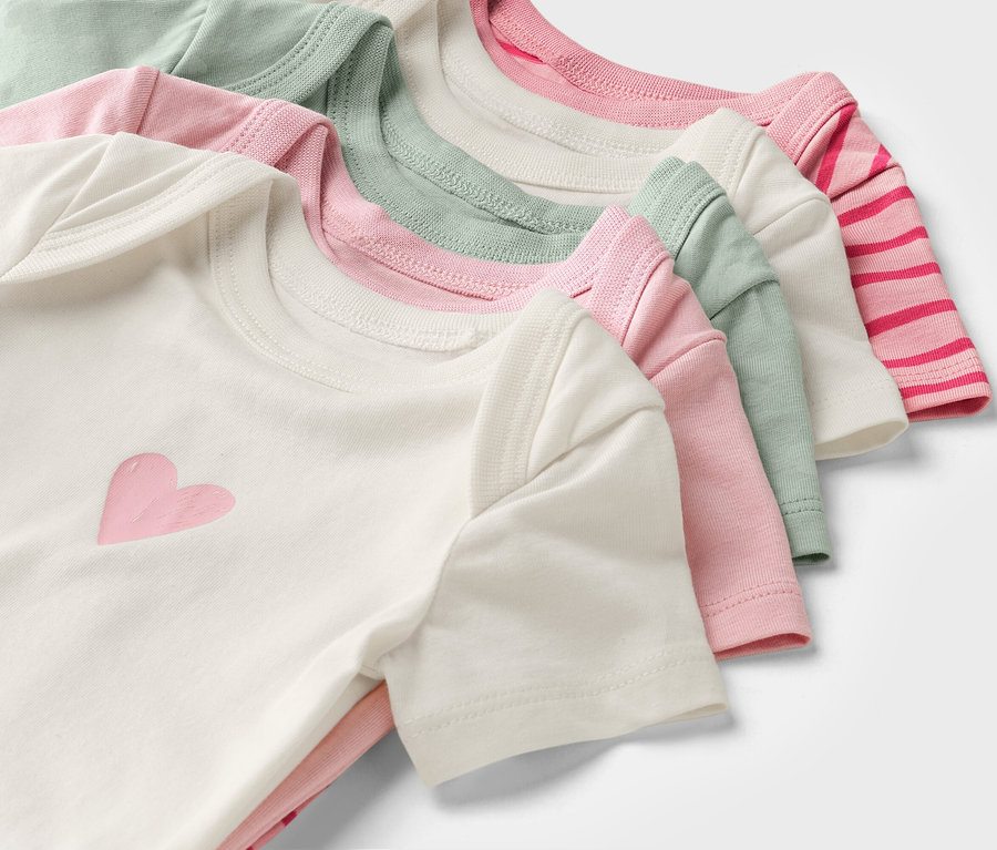 Mehrfarbige Kurzarm-Babybodys liegen gestapelt übereinander.