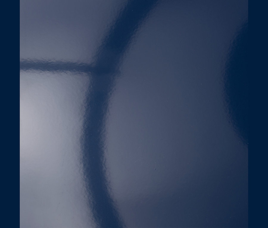 Dunkelblaue, glänzende Oberfläche mit Lichtreflexionen.