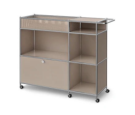 Ein beiges, modulares Rollregal mit Chromrahmen. Es hat oben links ein offenes Fach mit perforiertem Metallkorb, oben rechts zwei offene Ablagen mit einem Chromgriff, unten links einen geschlossenen Schrank mit Knopf und unten rechts zwei offene Ablagen.