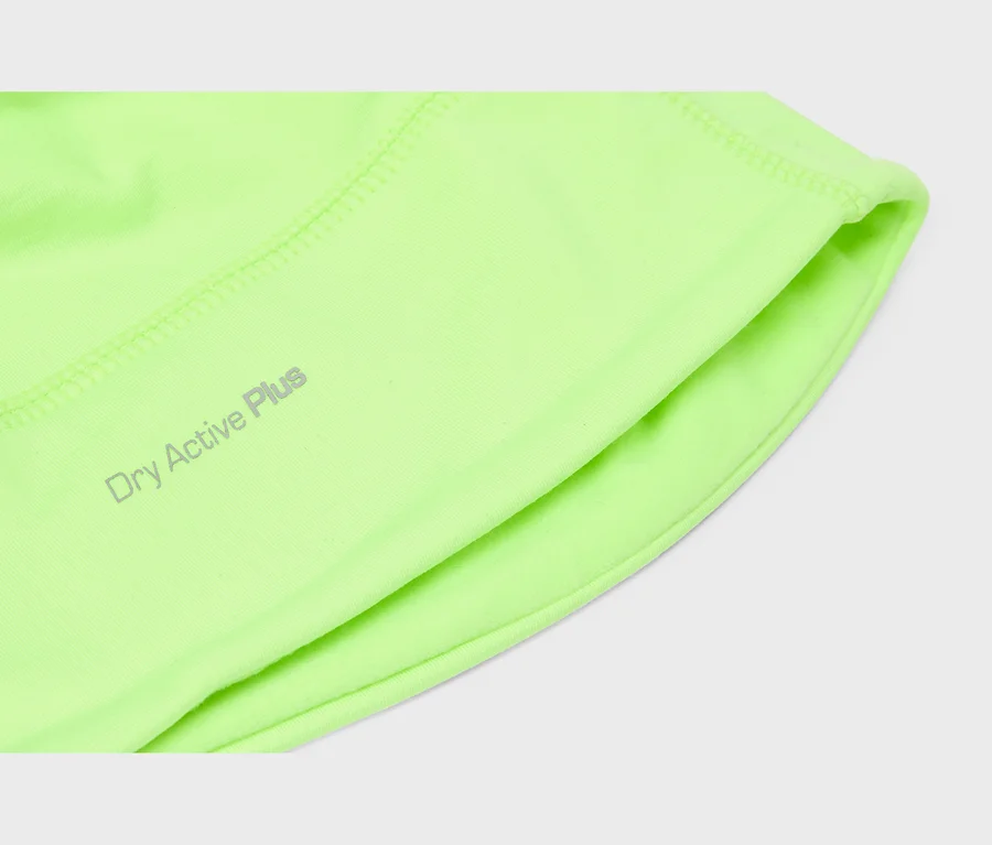Nahaufnahme eines neongrünen Sportbekleidungsstoffs mit dem grauen Aufdruck 'Dry Active Plus', der sichtbare Nähte und eine gefaltete Kante zeigt.