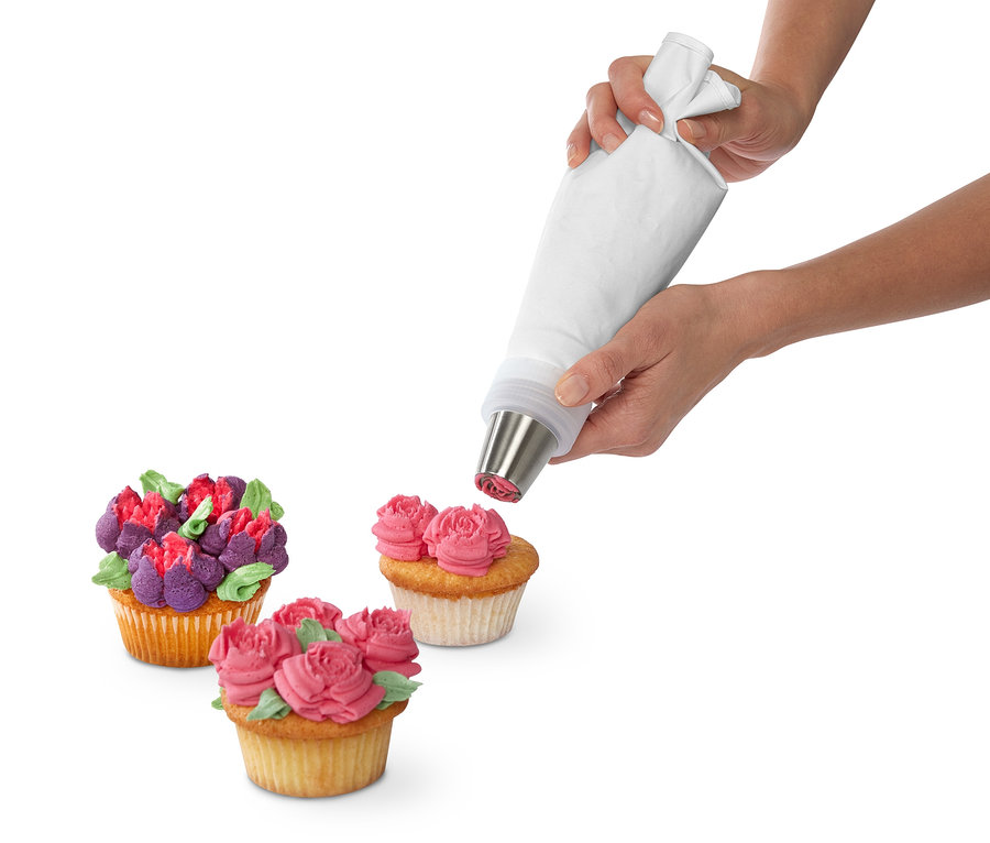 Eine Frau verziert einen Cupcake mit einem Spritztüllen-Set.
